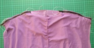 Reinforced shoulder seams, with floss used to gather the front of the seams. 